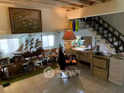 Charming study room with nautical decor and cozy workspace under staircase.