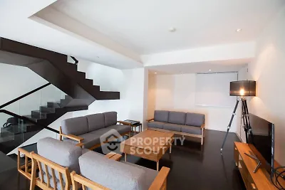 Modern living room with sleek staircase and stylish furniture