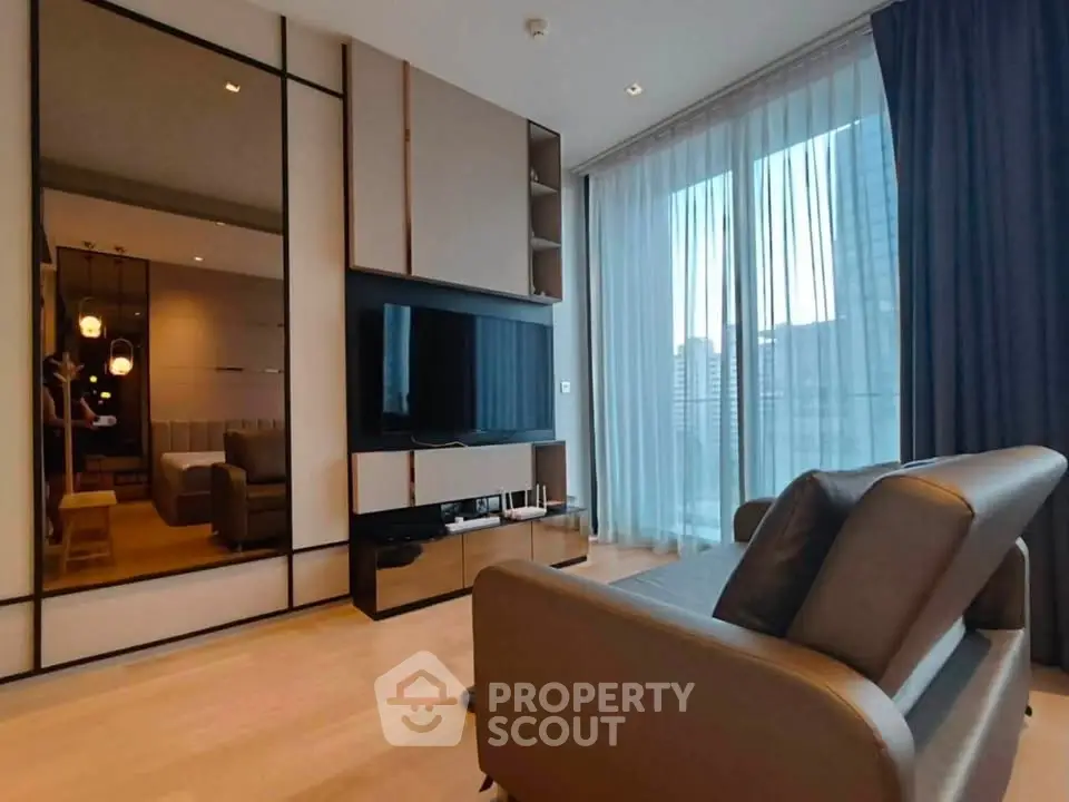 Modern living room with sleek design, large TV, and floor-to-ceiling windows offering city views.