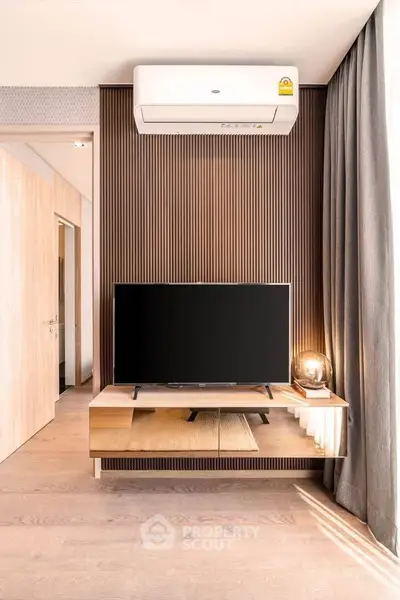 Modern living room with sleek TV setup and stylish wooden accents.