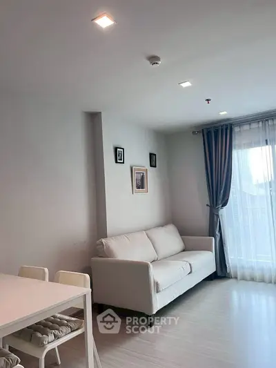 Modern living room with elegant sofa and natural light from large window.