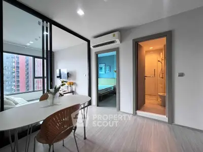 Modern apartment interior with open living and dining area, featuring sleek design and natural light.