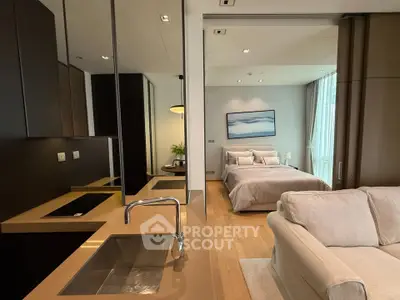 Modern open-plan living room and bedroom with sleek kitchen design in luxury apartment.