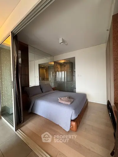 Modern bedroom with glass partition and cozy decor in a stylish apartment.