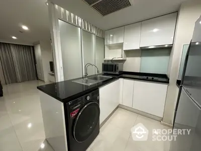 Modern kitchen with sleek white cabinets and built-in appliances in a contemporary apartment.