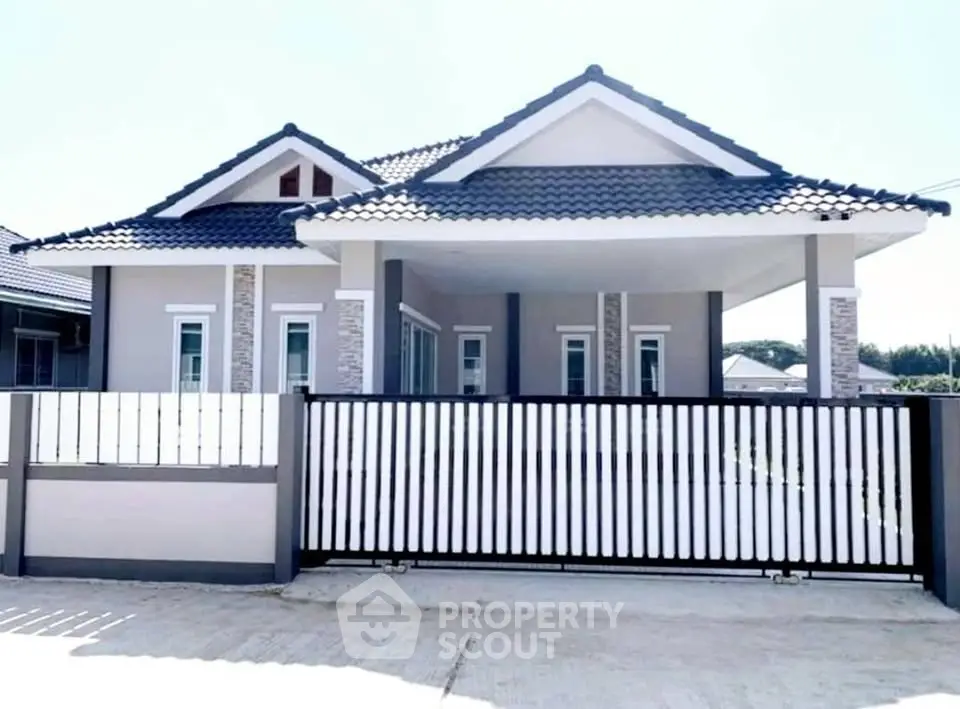 Charming modern house with stylish roof and gated entrance in serene neighborhood.