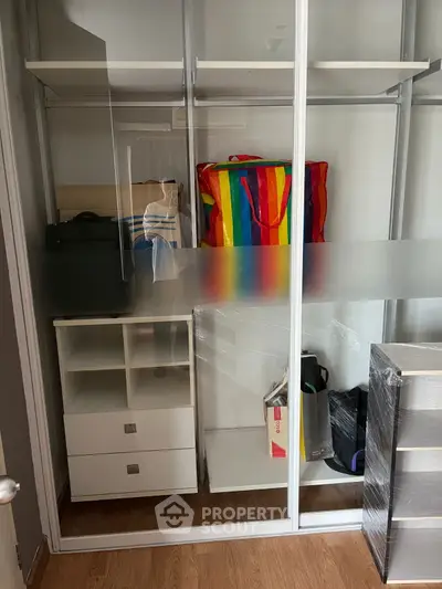 Spacious storage closet with sliding glass doors and organized shelving.