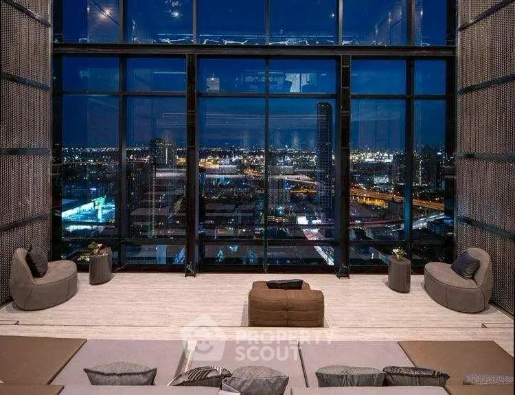 Luxurious high-rise living room with stunning cityscape night view through floor-to-ceiling windows.