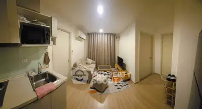 Cozy open-plan living room with modern kitchen and stylish decor in a compact apartment.