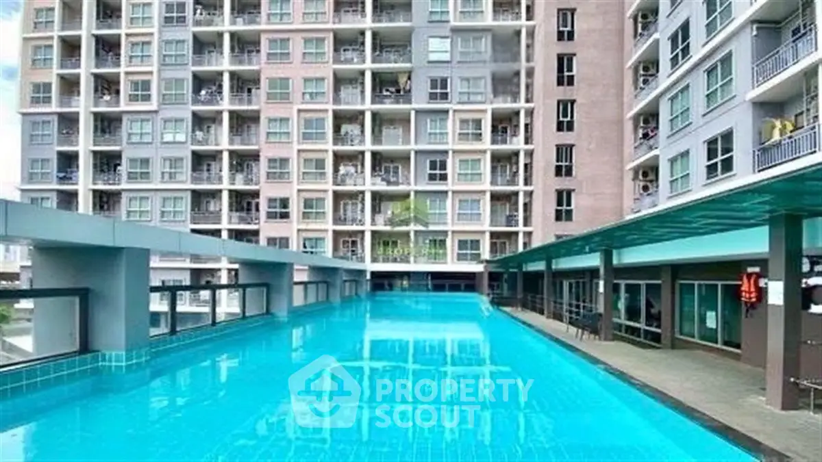 Modern condominium with a large swimming pool and stylish architecture.