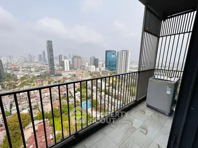 Stunning cityscape view from a high-rise balcony with modern railing and washing machine.