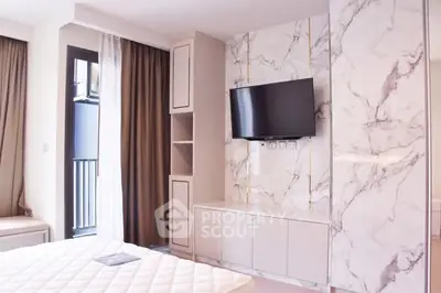 Modern bedroom with marble accent wall and mounted TV