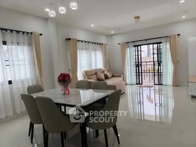 Spacious modern living room with elegant dining area and large windows.