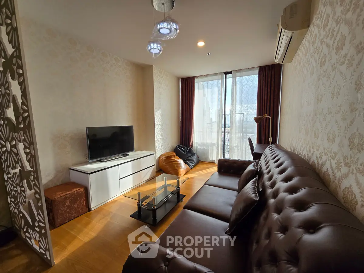 Luxurious living room with elegant decor and ample natural light, featuring a plush leather sofa and modern TV setup.