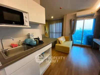 Modern open-layout kitchen and living room with city view balcony in stylish apartment.