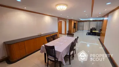 Spacious dining area with elegant wooden furniture and ambient lighting in a modern home.