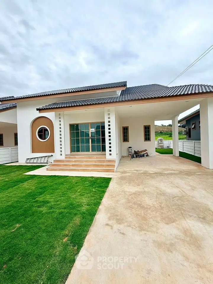 Charming modern house with spacious driveway and lush green lawn, perfect for family living.