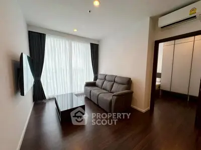 Modern living room with sleek furniture and large window in a stylish apartment.