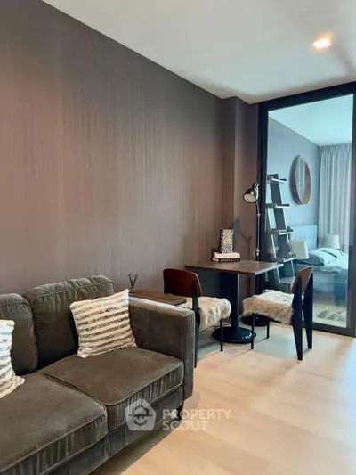 Modern living room with cozy sofa and stylish study area in open layout apartment.