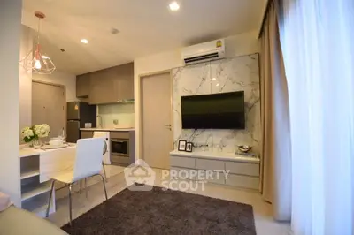 Modern living room with open kitchen, stylish decor, and natural light