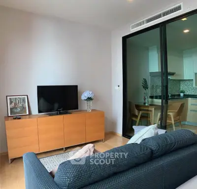 Modern living room with sleek furniture and open kitchen layout in a stylish apartment.