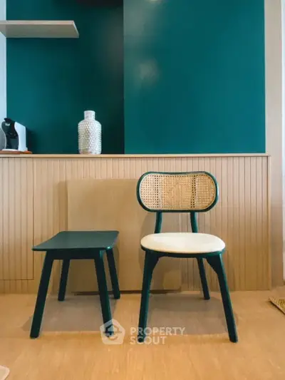 Stylish modern interior with chic chair and table against teal accent wall, perfect for contemporary living spaces.