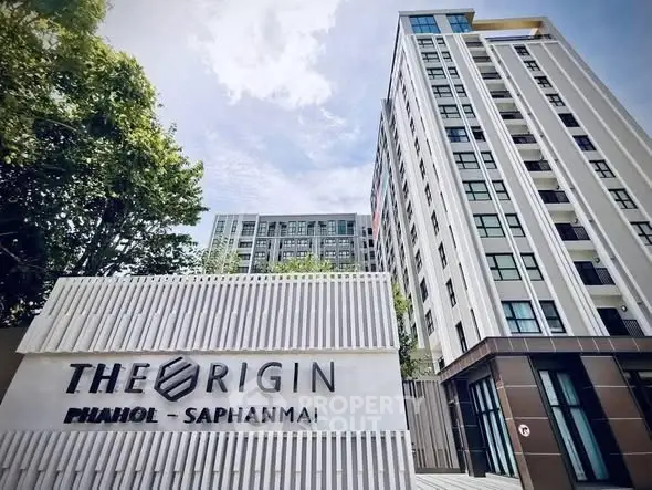 Modern high-rise condominium building with sleek design and lush greenery, ideal urban living in PHAHOL SAPHANMAI.