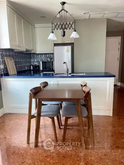Charming kitchen with blue countertops and modern dining set in cozy apartment.
