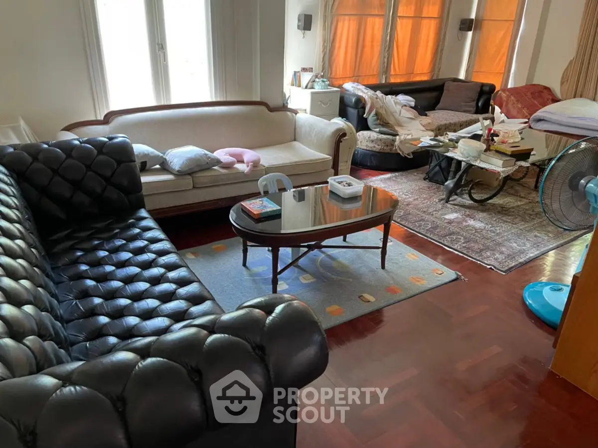 Spacious living room with elegant sofas and wooden flooring, perfect for relaxation and entertaining guests.