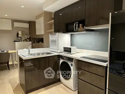 Modern kitchen with sleek cabinetry, integrated appliances, and stylish lighting in a contemporary apartment.
