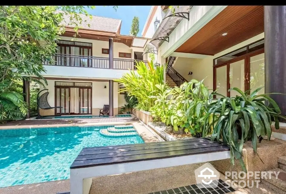 Luxurious villa with private pool and lush garden, featuring modern architecture and spacious outdoor seating area.