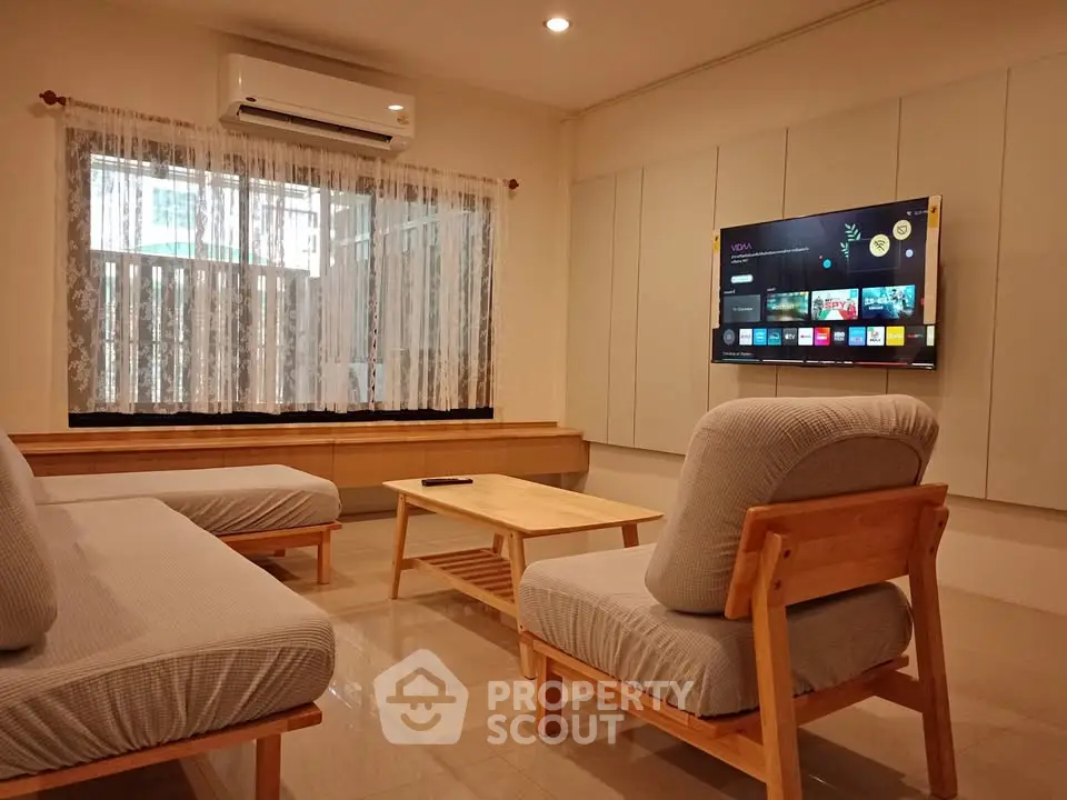 Cozy living room with modern furniture and wall-mounted TV, perfect for relaxation and entertainment.