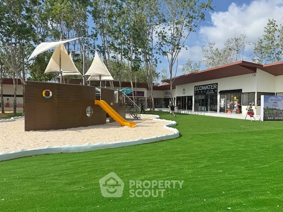 Charming community playground with artificial grass and modern play structures, ideal for family-friendly living.