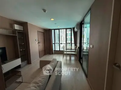 Modern living room with large windows and dining area in a stylish apartment.