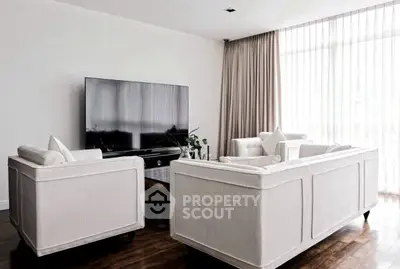 Elegant living room with modern furniture and large TV, featuring floor-to-ceiling windows and stylish decor.