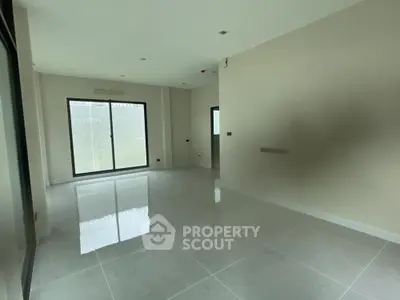 Spacious empty room with large windows and glossy tiled floor, perfect for customization.
