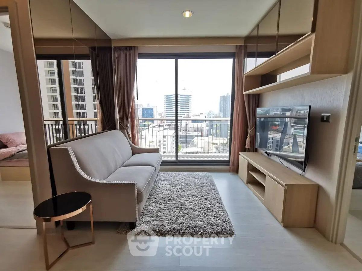 Modern living room with city view, stylish sofa, and entertainment unit in a high-rise apartment.