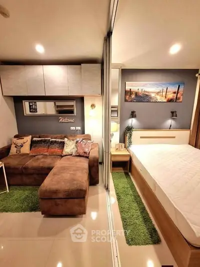 Modern studio apartment with cozy living area and stylish bedroom, featuring plush sofa and elegant decor.