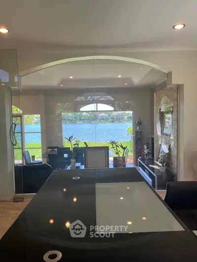 Luxurious living room with stunning lake view and modern glass table