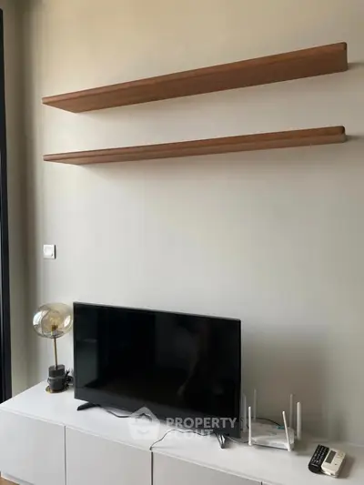 Modern living room with sleek TV setup and minimalist shelves