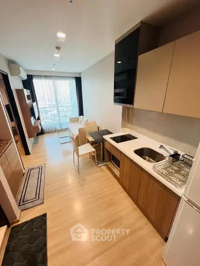 Modern open-layout kitchen and living room with sleek design and natural light.