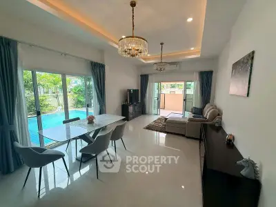 Spacious living room with pool view, elegant dining area, and modern decor.