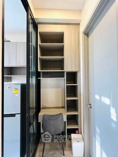 Compact study nook with modern shelving and chair in a cozy apartment corner.