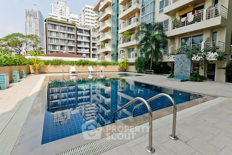Luxurious apartment complex with a stunning outdoor pool and modern architecture.