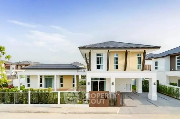 Modern two-story house with spacious driveway and lush greenery in a serene neighborhood.