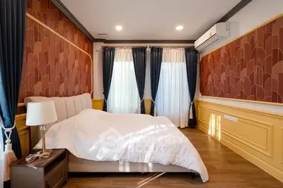 Elegant bedroom with stylish decor and natural light, featuring a cozy bed and modern air conditioning.