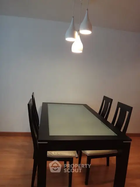 Modern dining area with sleek black table and stylish pendant lighting, perfect for contemporary living.