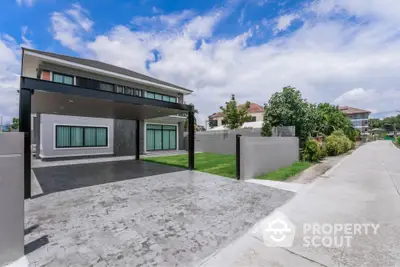 Modern two-story house with spacious driveway and lush greenery in a serene neighborhood.