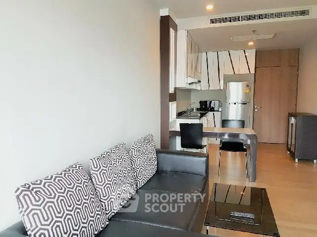 Modern living room with stylish kitchen and sleek furniture in open layout apartment.