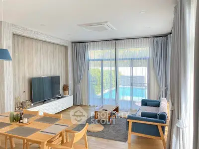 Spacious living room with pool view, modern decor, and natural light.